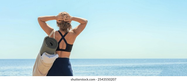 Active fitness yoga woman standing on cliff beach contemplate sea sky sunny landscape back view. Young sport female with rolled mat relaxing training exercise admiring cinematic seascape blue coast - Powered by Shutterstock