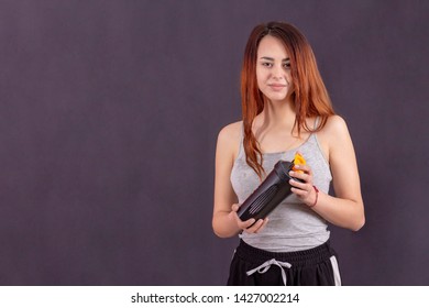 Active Girl After Jogging Drinks. There Is Sweat On His Forehead. Mike In Sweat Is Wet. Smiling Satisfied With Playing Sports