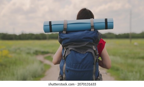 Active Girl With A Backpack Resting On A Camping Trip, A Millennial Traveler, Hiking In Nature, Lifestyle Of A Modern Man, Walking On A Dirt Road, Slow Motion