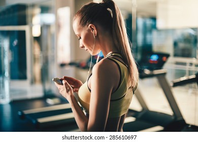 Active Girl With Smartphone Listening To Music In Gym