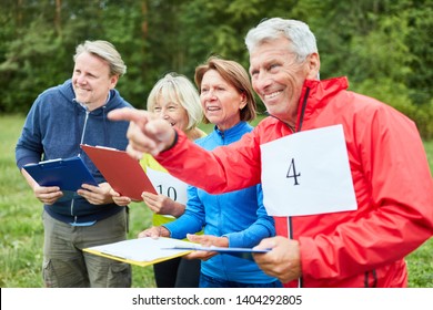 Active Group Of Seniors At Scavenger Hunt As A Game In Nature