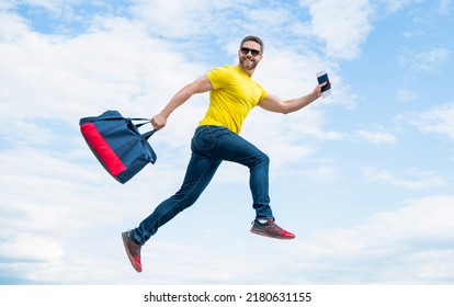 Active guy running with sporty bag midair sky background, sport