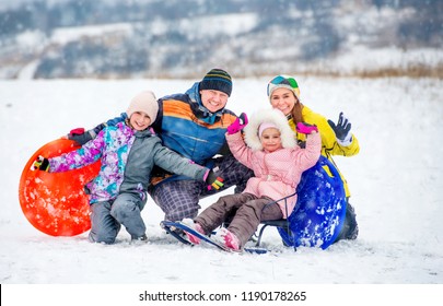 Active Happy Family Smiling And Laughing While Playing Outdoors During Winter Holidays. Winter Fun Outdoors With Children