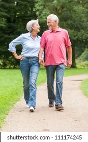 Active and happy senior couple walking in the park