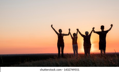 Active healthy family, grandmother with daughter and grandchildren meet the dawn, raise their arms above
