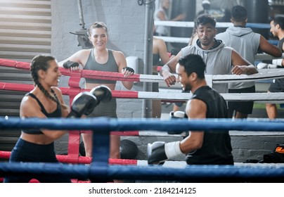 Active, healthy and fit diverse boxing group training and working out together in a gym. Sports group doing a strength fight exercise while people watch. Smiling fitness team in a friendly workout - Powered by Shutterstock