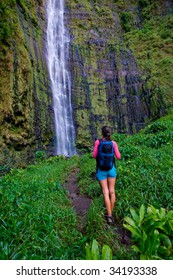 Active Healthy Woman On Hike To Waterfall With Backpack In Hana Maui, Hawaii