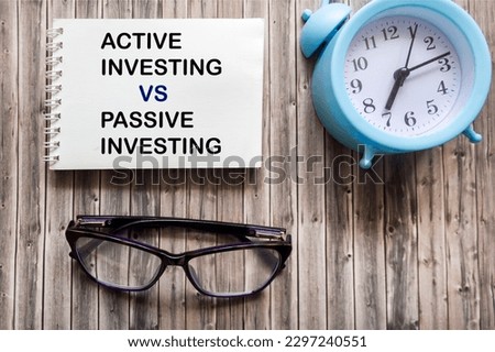Active investing vs passive investing pros and cons text on notepad