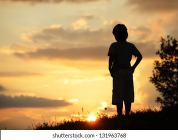 Active kid spending time on summer meadow by sunset