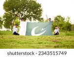 active kids celebrating Independence day, 14th of August, Pakistan, with  waving Pakistani flag. 