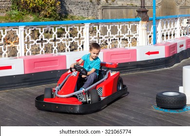 Active Little Boy Driving A Race Car