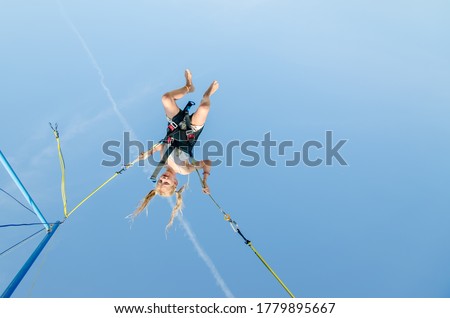 Similar – Image, Stock Photo Bungee jumping at trampoline. Little girl bouncing on bungee jumping in amusement park on summer vacations