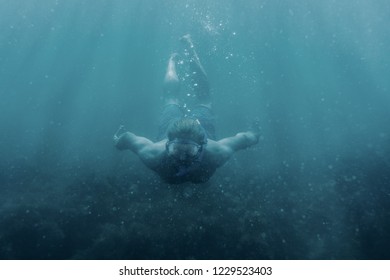 Active Male Freediver In Mask Swimming Underwater, Front View.