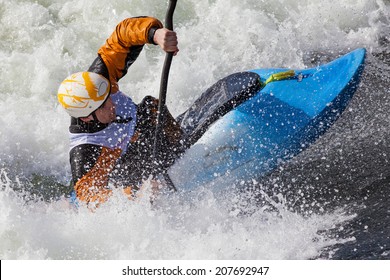 An Active Male Kayaker Rolling And Surfing In Rough Water