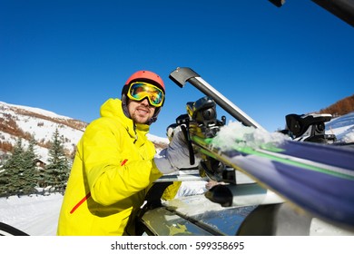 Active Man Fastening Skis On The Roof Of Car