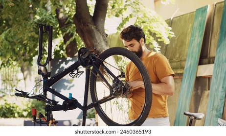 Active man outside demonstrating commitment to repairing and securing bicycle components for summer cycling leisure. Caucasian male selecting professional equipment for bike maintenance. - Powered by Shutterstock