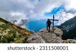 Active man at summit cross near Santa Maria del Castello. Scenic view on coastal town Positano, Praiano. Magical hiking trail, Lattari Mountains, Apennines, Amalfi Coast, Campania, Italy, Europe