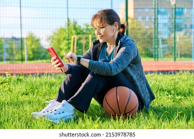 Active Mature Woman With Basketball Ball And Smartphone, Outdoor