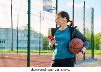 Active Mature Woman With Basketball Ball And Smartphone, Outdoor