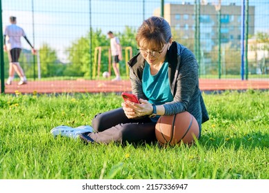 Active Mature Woman With Basketball Ball And Smartphone, Outdoor