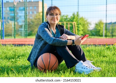 Active Mature Woman With Basketball Ball And Smartphone, Outdoor