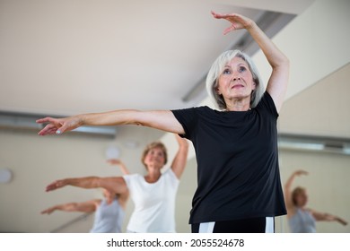 Active Mature Woman Visiting Choreography Class With Group Of Aged Females, Learning Classical Ballet Technique .