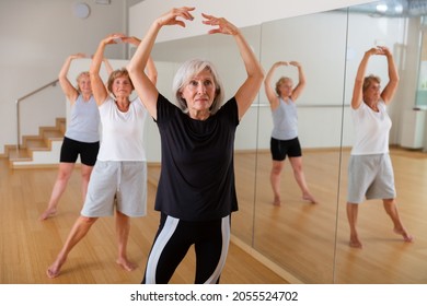 Active Mature Woman Visiting Choreography Class With Group Of Aged Females, Learning Classical Ballet Technique .