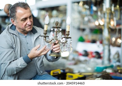 Active Middle Aged Man Buying Retro Handicrafts On Indoor Flea Market