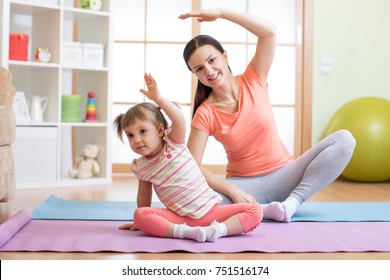 Active Mom And Child Daughter Are Engaged In Fitness, Yoga, Exercise At Home