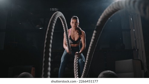 Active motivated female athlete training in gym, having a cross fit session with battle ropes, achieving goals enjoying healthy lifestyle  - Powered by Shutterstock