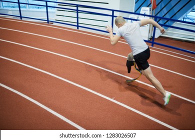 Active Paralympic Runner With Handicapped Leg Moving Fast On Track Line At Stadium During Competition