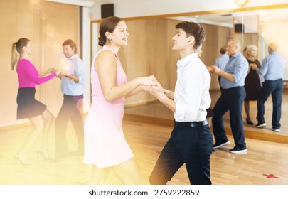 an active and positive slender guy made couple in jive to smiling young woman