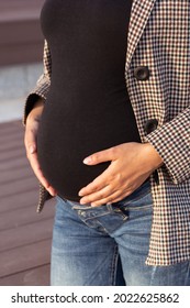 Active Pregnancy Concept. Close-up Of Belly Of Happy Young Business Or Student Pregnant Woman Standing In A Park. Future Mom Working Or Studying On Her Late Pregnancy Period.