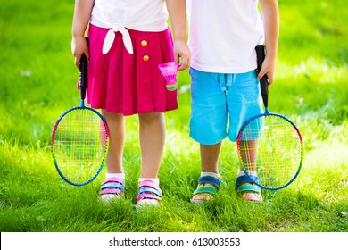 Active preschool girl and boy playing badminton in outdoor court in summer. Kids play tennis. School sports for children. Racquet and shuttlecock sport for child athlete. Kid with racket and shuttle