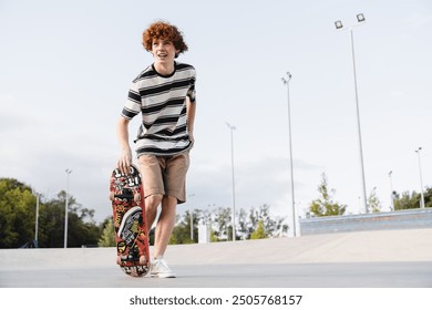 Active redhead caucasian curly teen school boy guy teenager skater in casual riding on skateboard spending time in skate park ramp urban street . Summer holiday active sports concept - Powered by Shutterstock