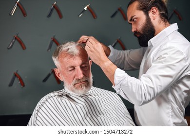 Active Retired Old Man Getting Haircut By Experienced Barber In Barber's Shop.close Up Photo