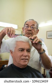 Active Retired Old People, Man Getting An Haircut By Senior Barber In Old Fashion Barber's Shop. Copy Space