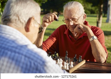 Active Retired People, Old Friends And Free Time, Two Senior Men Having Fun And Playing Chess At Park. Head And Shoulders