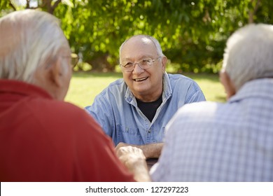 Active Retired Senior People, Old Friends And Leisure, Group Of Four Elderly Men Having Fun, Laughing And Talking In City Park. Waist Up