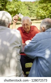 Active Retirement, Old People And Seniors Free Time, Group Of Three Elderly Men Having Fun And Playing Cards Game At Park. Waist Up