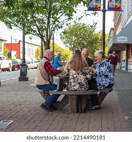 Active Retirement, Old People And Seniors Free Time, Group Of Four Elderly Men Having Fun And Playing Cards Game At Park. Street Photo, Selective Focus-October 6,2022-Ladysmith BC Canada