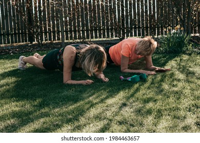 Active Senior 55-59 Years Women Perform Exercises In The Rays Of The Sun Outdoors, Plank Position