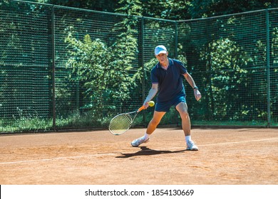 Active Senior Caucasian Man In Sportswear Playing Tennis, Hits A Forehand Groundstroke