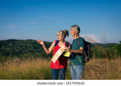 Active Senior Couple With Backpacks Hiking In Nature.