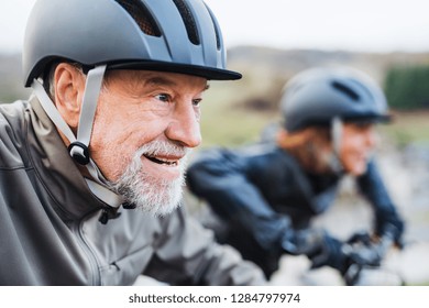 Active senior couple with electrobikes cycling outdoors on a road in nature. - Shutterstock ID 1284797974