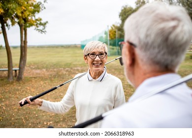 An Active Senior Couple With Golf Clubs Enjoying Free Time Outdoors.