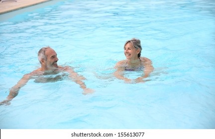 Active Senior Couple In Resort Pool