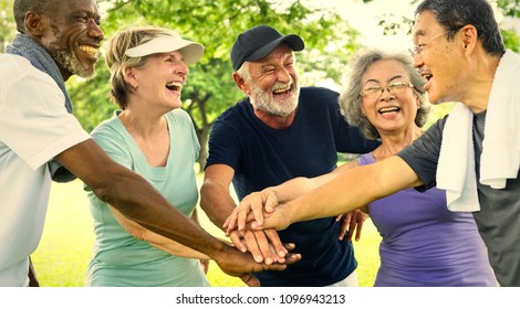 Active Senior Friends Exercising At The Park