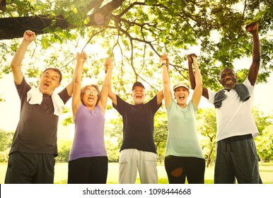 Active Senior Friends Exercising At The Park