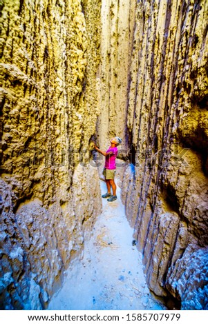 Active Senior hiking through the dramatic and unique patterns of Slot Canyons and Hoodoos caused by erosion of the soft volcanic Bentonite Clay in Cathedral Grove State Park in the Nevada Desert, USA